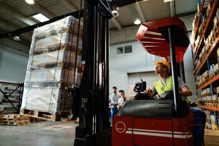 forklift-operator-loading-cargo-while-working-warehouse-his-colleagues-are-background